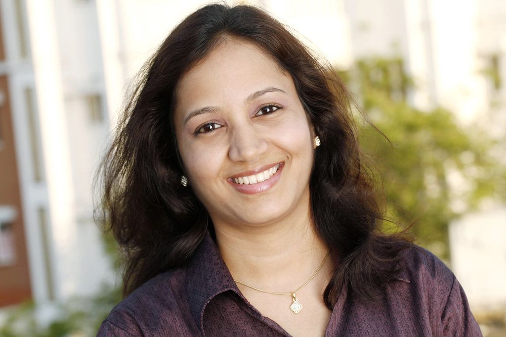 Dark-haired woman smiling outdoors