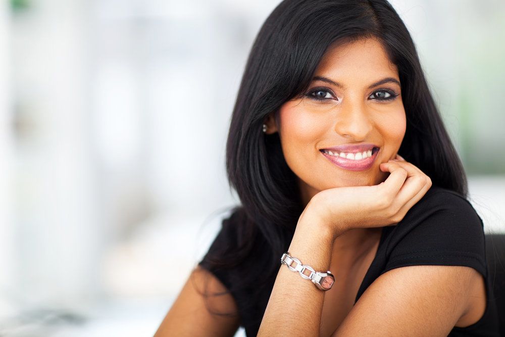 Dark-haired woman smiling indoors